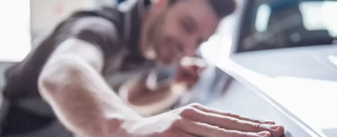 auto body working looking for scratch in car paint